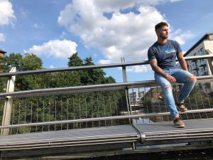 Model wearing Retro75 blue t-shirt leaning on the bridge